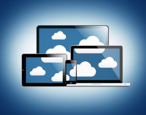 Devices connected by the digital cloud - Cloud computing concept with laptop, desktop, tablet and smartphone